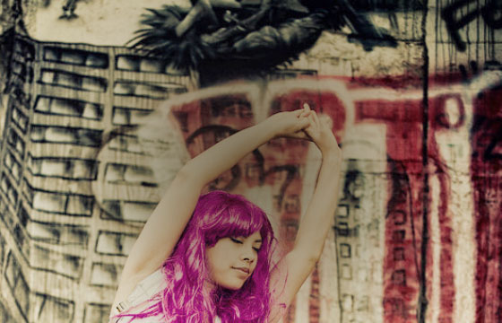 Oberkörper einer Tänzerin in Pose mit pinken Haaren