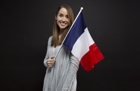 Junge Frau mit Frankreichflagge lächelt in die Kamera